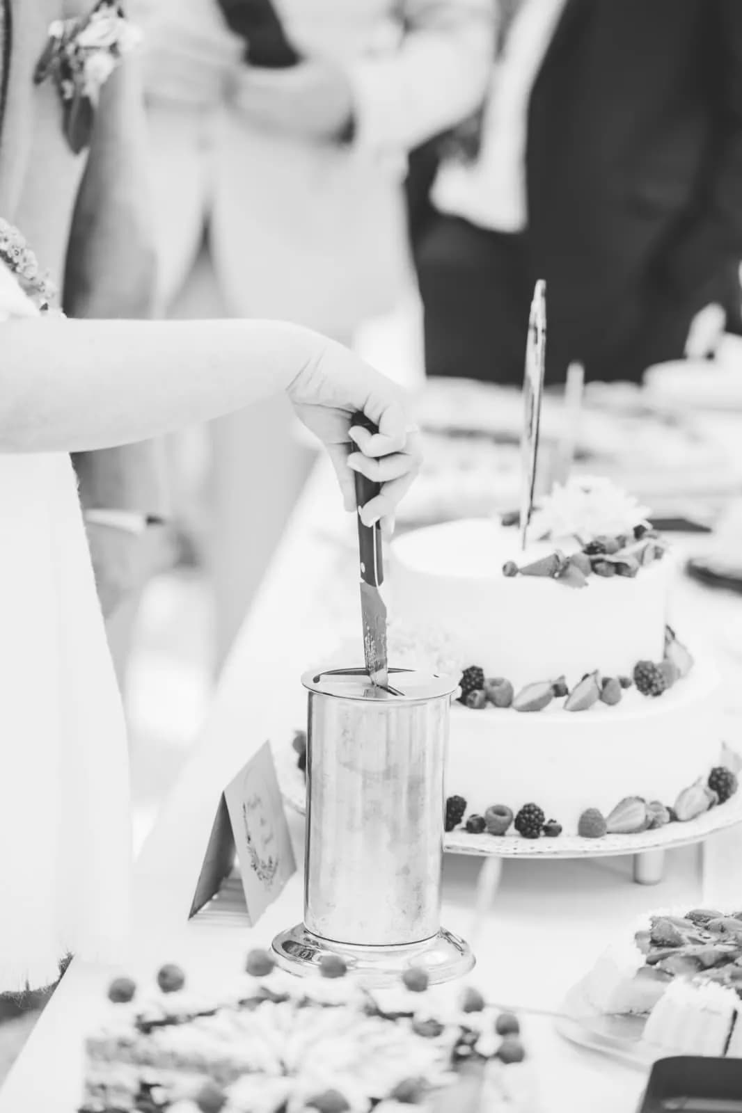 Das Brautpaar schneidet die Torte an, schwarz-weiß