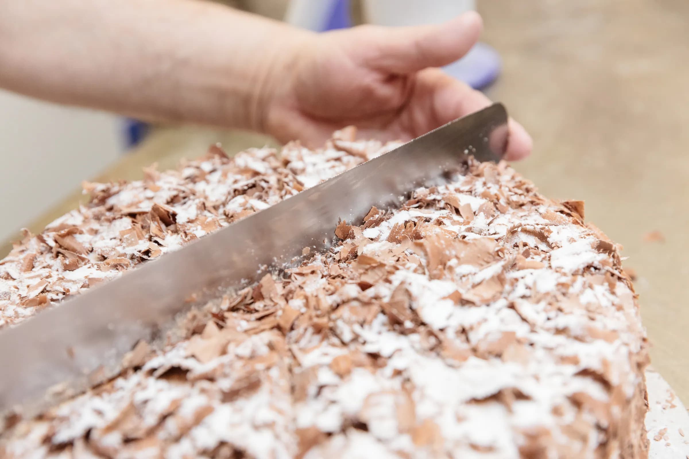Schokosahnetorte wird mit dem Messer eingeteilt