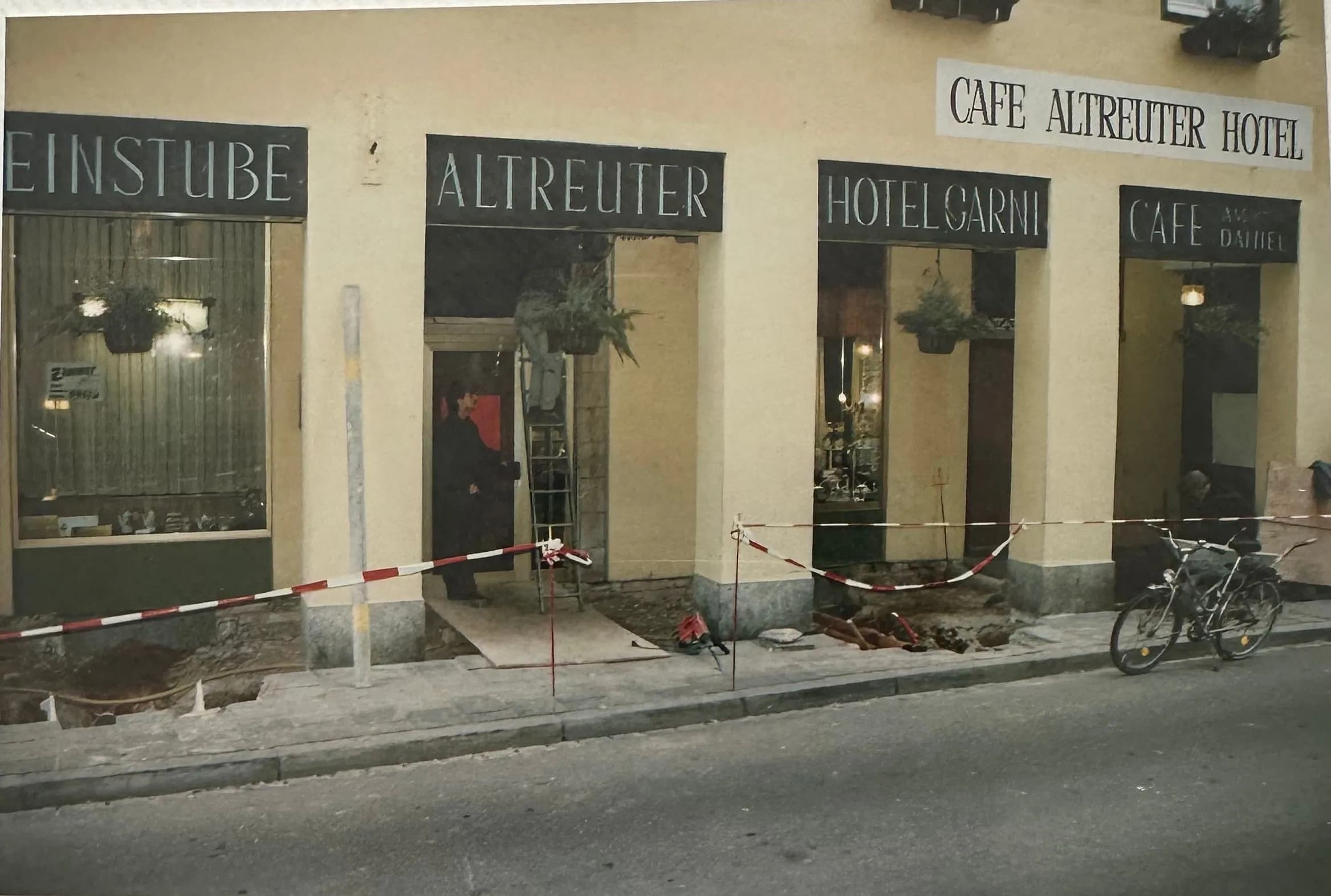 Umbau: das Erdgeschoss mit den Schildern Weinstube, Altreuter, Hotel garni und Café, davor der aufgegrabene Gehweg